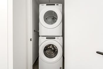 Two white front loading washing machines in a small room.